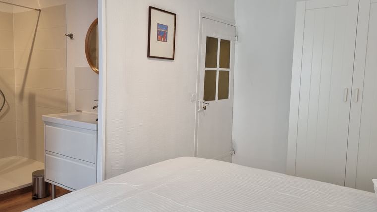 Chambre avec commode et accès à la douche